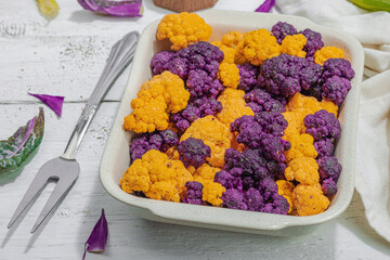 Cauliflower, yellow and purple, ready to bake. Healthy food, spices, olive oil. Hard light