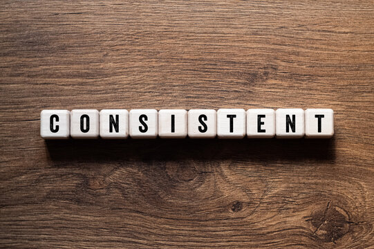 Consistent - word concept on building blocks, text