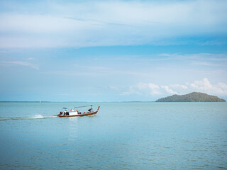 Obraz premium Fishing boat on the water. Port coastline in the background with a small island ,sea and sky with copyspace