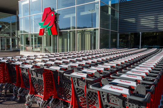 Gap, France - 6 ao&ucirc;t 2023: Rang&eacute;es de nombreux chariots de courses &agrave; l'ext&eacute;rieur d'un supermarch&eacute; Auchan. Auchan est une entreprise fran&ccedil;aise et une enseigne de grande distribution