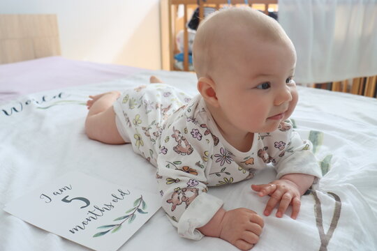 little baby girl lies on a sheet 5 months old