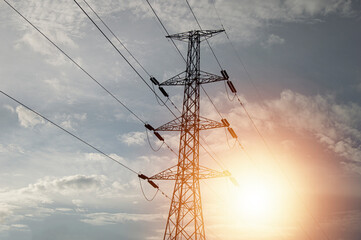 High voltage towers at sunset background. Power lines against the sky