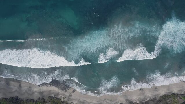 Aerial Drone Top Down shot of surfers in crystal water at Playa Negra Costa Rica