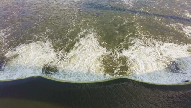 Aerial view of texture and surface of seawater falls foaming on the outfall