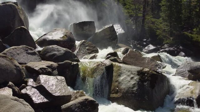 Close-up view of a river crashing on massive rocks in a wild nature