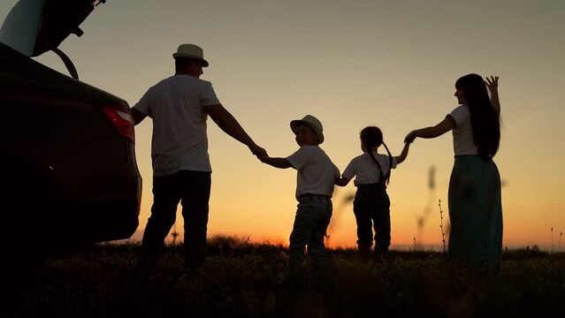 Dad with child, daughter on his shoulders, mom, children dance and admire beautiful sunset. Parents and children stopped at campsite by car. Happy family travels by car. Big family, Travel by car. Kid