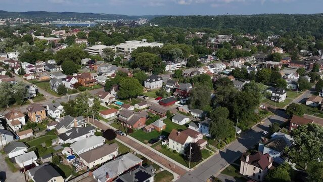 A high angle wide rotating orbiting parallax view of Beaver, Pennsylvania, a small town residential neighborhood suburb of Pittsburgh. Bridges over the Ohio River in the distance.  	