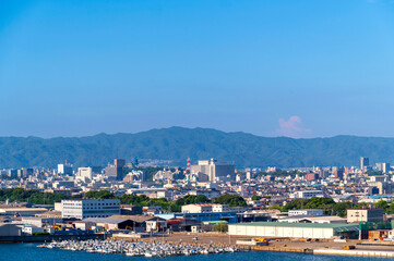 Fototapeta na wymiar Wakayama cityscape with port and industry factory and blue sky background, Wakayama city, Japan