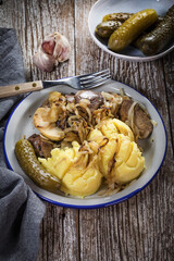 Fried liver with onion and apple, served with boiled potatoes and pickled cucumber.