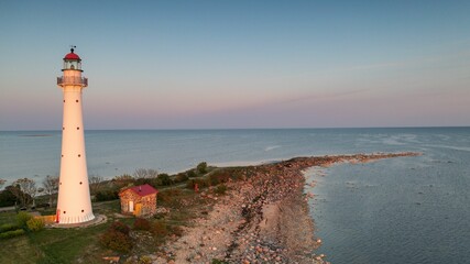 Stunning view of the Kihnu lighthouse against a backdrop of the sea at sunset