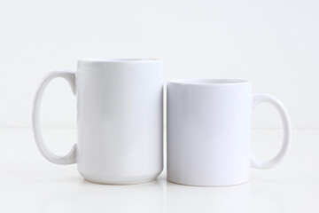 Blank 2 White mug on a white isolated background . 11 oz and 15 oz cups mock up	