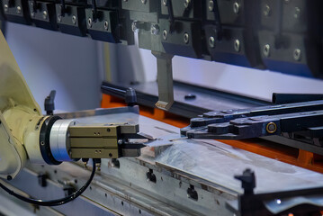 Close up the sheet metal bending process by robotic arm.