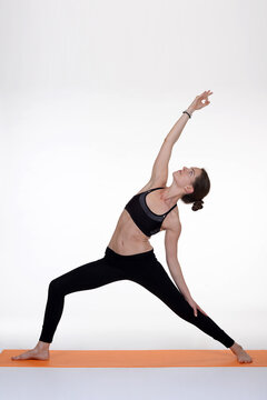 Woman doing yoga in photo studio on isolated white background.