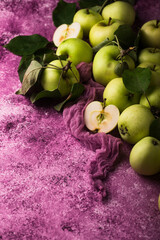 Fresh ripe green apple in purple background.