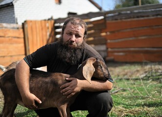 bearded man hugging a goat