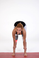 Woman doing yoga in photo studio on isolated background.