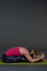 Fototapeta na wymiar Woman doing yoga in photo studio on isolated grey background. 