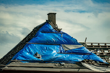 Abgedecktes und beschädigtes Dach am Altbau