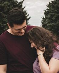 Fototapeta premium Vertical closeup shot of a young couple laughing and having fun together
