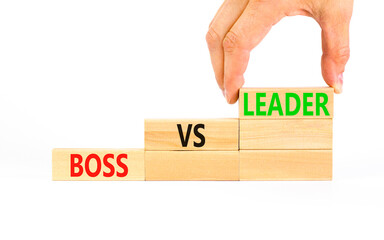 Boss vs leader symbol. Concept words Boss vs versus leader on wooden block. Beautiful white table white background. Businessman hand. Business motivational boss vs leader concept. Copy space.