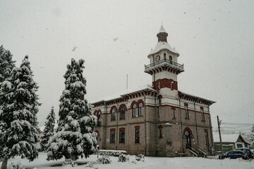 Obraz premium Beautiful shot of the historic Targu Ocna Town Hall covered in snow