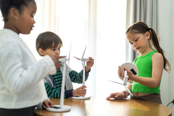 Fototapeta premium Portrait happy teacher help school children student having fun activity learn play renewable energy from solar windmill, education, science, environment, Eco, wind turbines, class at elementary school