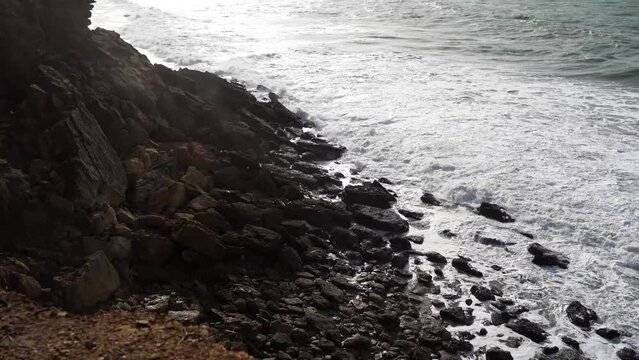 Aerial view of sea waves breaking rocky beach