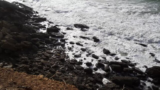 Aerial view of sea waves breaking rocky beach