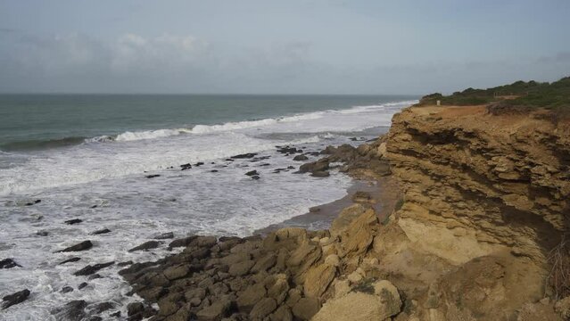 Aerial view of sea waves breaking rocky beach