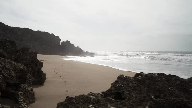 Aerial view of sea waves breaking rocky beach