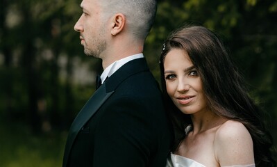 Bride and groom posing together in a green garden on their wedding day