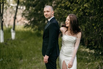 Bride and groom posing together in a green garden on their wedding day