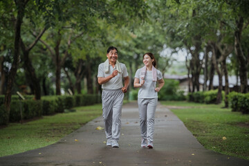 Young beautiful asian woman jogging with her father in park happily, with a smile. Asian woman...