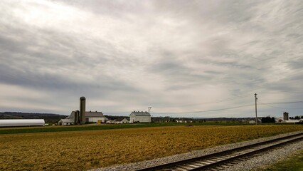Fototapeta na wymiar An Amish farm with barns and silo on a cloudy day.