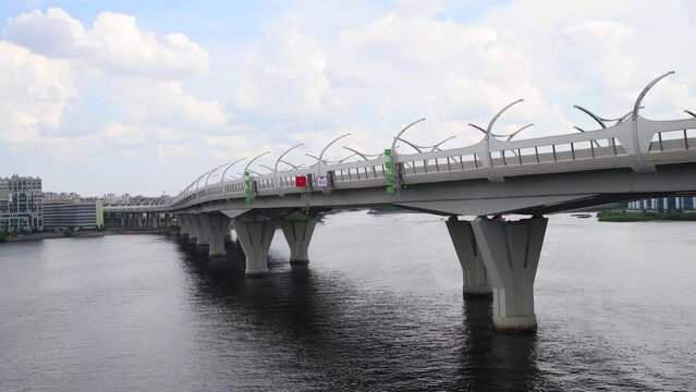 Side view of western high-speed diameter with bridge standing above river water in Saint Petersburg city, Russia. Cloudy sky. Real time video. Urban architecture theme.