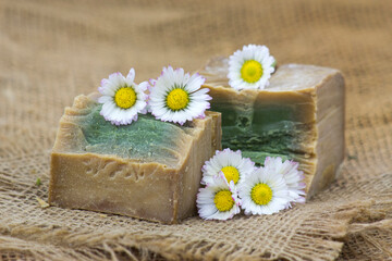 Obraz na płótnie Canvas bar of natural soap and daisy flowers
