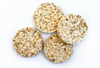 Puffed rice cakes isolated on white background, closeup. Four round crispy rice waffles. Whole grain brown rice thin crackers or crispbread,  healthy food, dietary product with low calories.