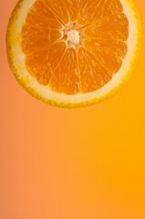 Vertical of fresh orange cut on an orange background