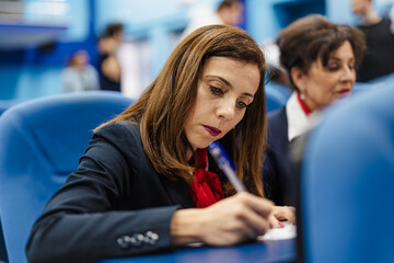 Female professor filling out/writing a document