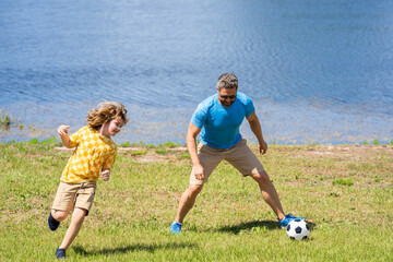 Obraz premium dad have fun with his son. dad and son enjoying childhood adventures outdoor. dad and son playing football during their childhood. Childhood memories of son and his dad. creating lasting memories