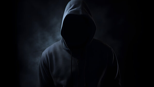 Person silhouette in hoodie behind dark background