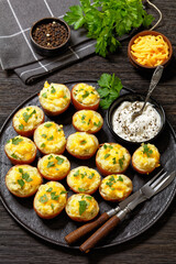baked stuffed red potatoes on black plate