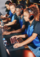 Professional cybersport team wearing headphones participating in eSport tournament, playing online video games while sitting in gaming club or internet cafe © Friends Stock
