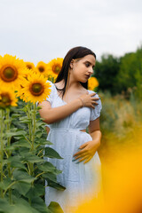 pretty young girl is looking at a sunflower field