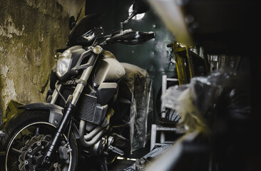 Dusty Motorcycle in a Warehouse 
