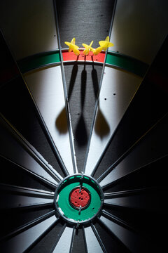 3 mini darts in a triple ring on a dartboard.