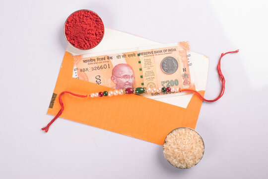 Rakhi with indian currency on white background