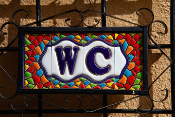 Typical WC signpost on the wall from ceramic shards