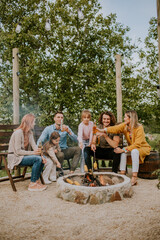 Friends having good time and baking corns in the house backyard