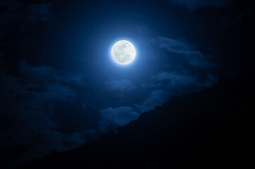 Full Moon Over Cloudy Night Sky and Mountain Silhouette © zinedine